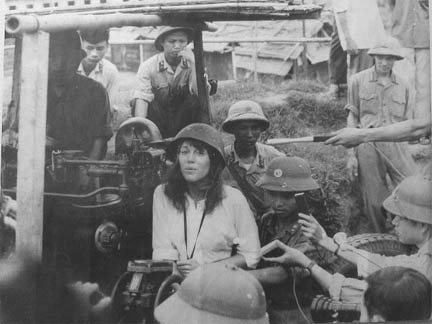 Jane Fonda mirthfully posing with enemy North Vietnamese soldiers