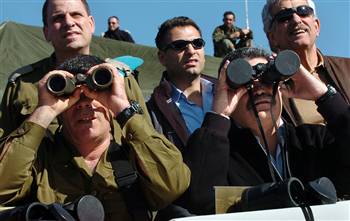 Israel's Defense Minister Amir Peretz (right) looks through binoculars with the lens cap on. On the left is the army's new Chief of Staff, Lt. Gen. Gabi Ashkenazi. They're reviewing a military drill in the Golan Heights. <font face=Arial size=-2>(Source: msnbc.com)</font>