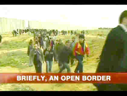 Gazans pour through hole blasted in border wall with Egypt. <font face=Arial size=-2>(Source: BBC)</font>