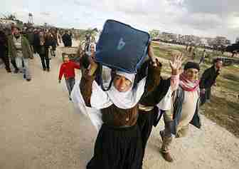 Euphoric Gazans carry goods back to Gaza from Egypt. <font face=Arial size=-2>(Source: Der Spiegel)</font>