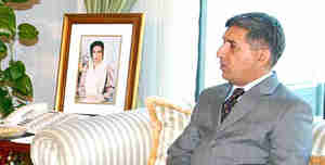 File photo of ISI chief Shuja Pasha.  The photo on the desk next to him is of Benazir Bhutto, the assassinated wife of Pakistan's president Asif Ali Zardari.