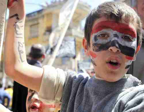 A Lebanese child with a Syrian flag painted on his face, and the phrase 'Bring down the regime' written on his hand, in solidarity with Syria's protesters (Xinhua)