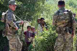 Turkish soldiers guard border as Syrian refugees await authorization to enter (AP)