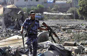 Hamas official surveys the damage from an Israeli airstrike in Gaza on Sunday (Reuters)