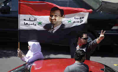 Pro-Assad demonstrators in central Damascus on Saturday (AFP)