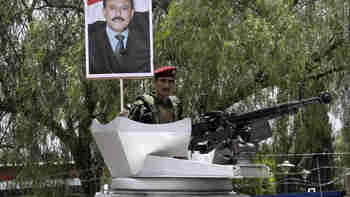 A Yemeni soldier holds up a picture of President Ali Abdullah Saleh during a rally in support of his regime on Friday (CNN)