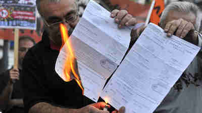 Members of the 'we won't pay' movement in Athens burn their tax bills (AFP)