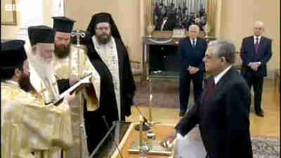 Lucas Papademos receives a blessing from Archbishop Ieronymos