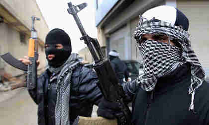 Free Syrian Army fighters patrol a street in Damascus suburb (Reuters)