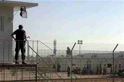 A guard watches over illegal immigrants inside a newly-built detention camp