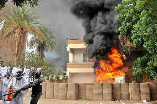 Sudanese policemen stand guard after protesters attacked the German and British embassies in Khartoum