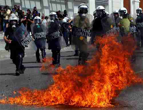  A molotov cocktail explodes beside riot police officers near Syntagma square in Athens. (Reuters)