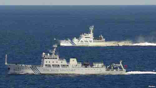 Chinese surveillance ship in front, Japanese coast guard ship in back (Kyodo)