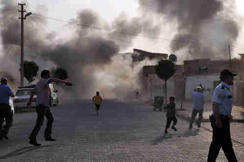 People run for cover in Akcakale Turkey after mortar shells from Syria hit the town.  (EPA)