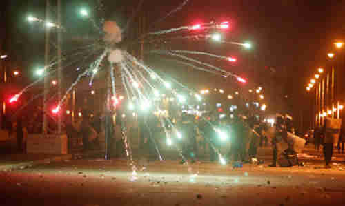 Protesters throw fireworks at police in Cairo on Friday (Reuters)