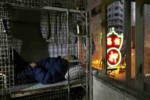 62-year-old Cheng Man Wai lies in his home, 16 sq. ft. cage (AP)