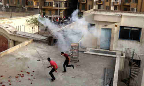 Coptic Christians flee teargas on the cathedral roof on Sunday (Reuters)