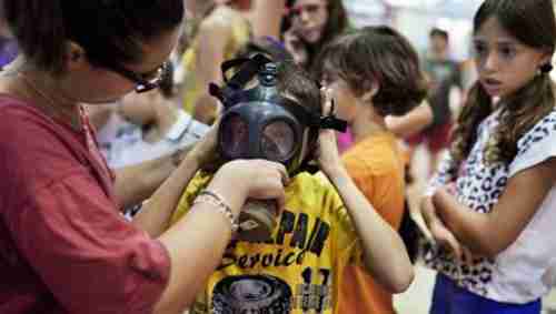 Israeli child being fitted with a gas mask