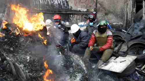 Protesters sit behind a barricade in Kiev on Tuesday (CNN)