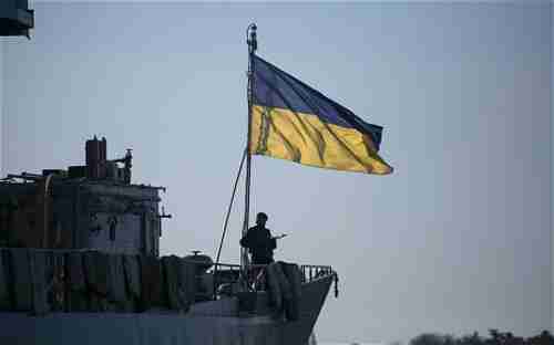 A member of the Ukrainian Navy stands guard on top of the Ukrainian navy command ship Slavutych in Sevastopol.  Russian ships are blockading the Ukrainian ships.