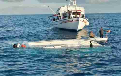 A fishing boat approaches the capsized vessel that had had 65 passengers on Monday (Kathimerini)