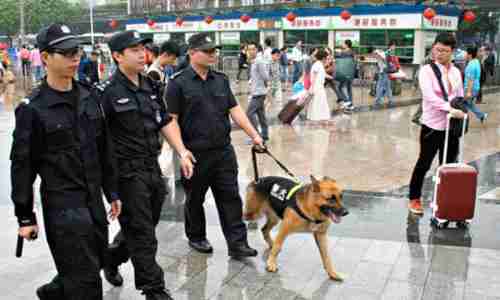 Police officers patrol at Guangzhou railway station after Tuesday's knife attack (Getty)