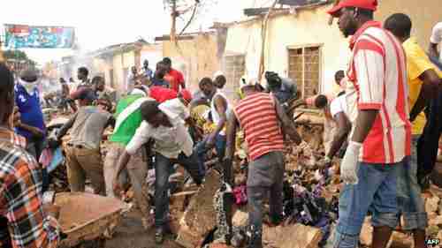 Shopkeepers in Jos salvage belongings after the attack (AFP)