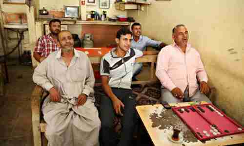 Men watching Nouri al-Maliki's speech on a TV in a Baghdad cafe, thanking Syria for the air strikes (AP)