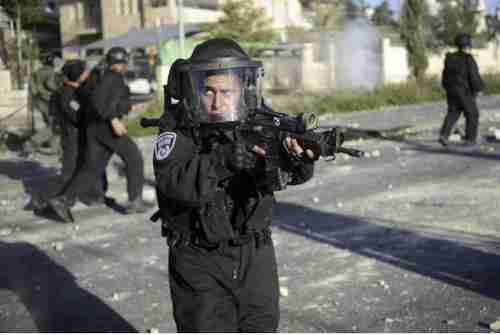 Israeli policeman aims his weapon during clashes with Palestinians on Thursday (AP)