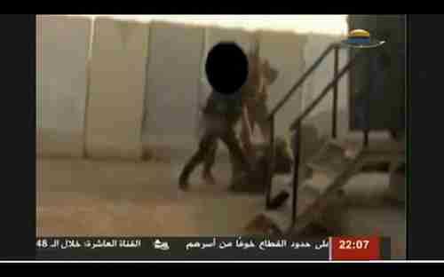 Screen grab from Hamas video showing Hamas fighters kicking Israeli soldier