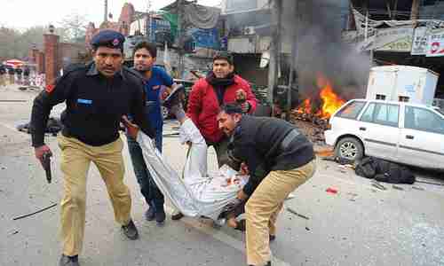 Police rush an injured man to hospital after suicide bombing in Lahore on Tuesday (AP)