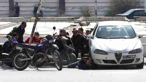 Police take up position behind a car near the museum on Wednesday