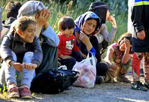 A group of Afghans rest after crossing illegally from Serbia into Hungary near the village of Asotthalom, Hungary (Reuters)