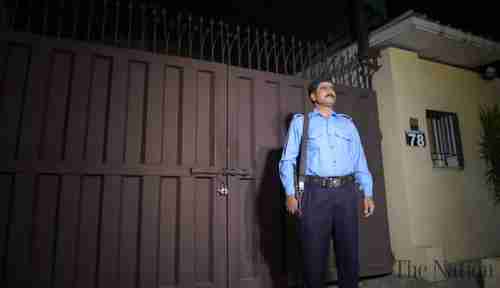 A guard stands in front of the locked and sealed Save the Children office in Islamabad (The Nation)