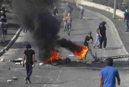 Palestinians set tire on fire during clashes with police in East Jerusalem on Sunday (Reuters)