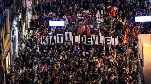 Anti-government protesters carry placards reading, 'The Murderous State'