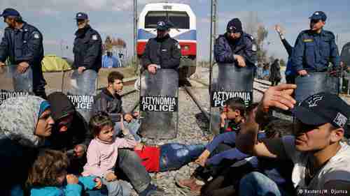 Migrants block the railway track at the Greek-Macedonian border (Reuters)