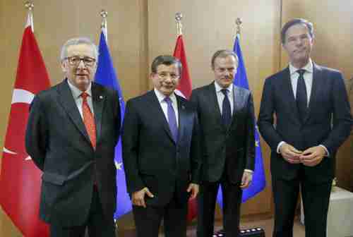 Friday in Brussels: The three EU officials look grim.  The only one smiling is the Turkey's prime minister Ahmet Davutoglu, second from the left.  (AFP)