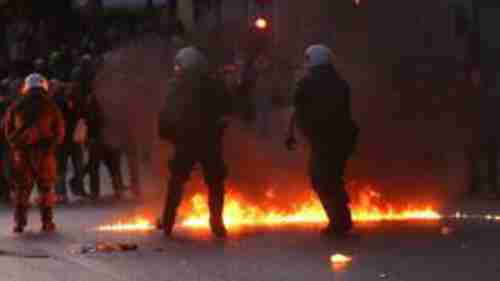 Protesters in Greece have hurled petrol bombs at police who responded with tear gas outside the parliament in Athens. (EPA)