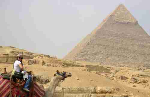 A tourist rides a camel in front of the Giza pyramids (Reuters)