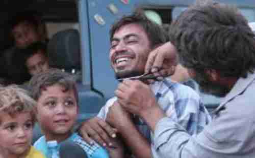 A man's beard is cut off in Manbij on Saturday (Reuters)