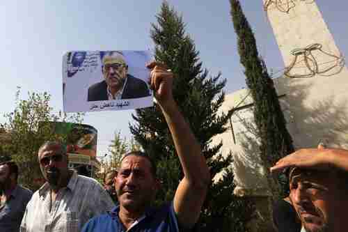 A mourner holds up a photo of Nahed Hattar, who was murdered on Sunday (Reuters)