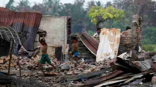 Children recycle goods from the ruins of a market in a Rohingya village that was burned down two weeks ago (Reuters)