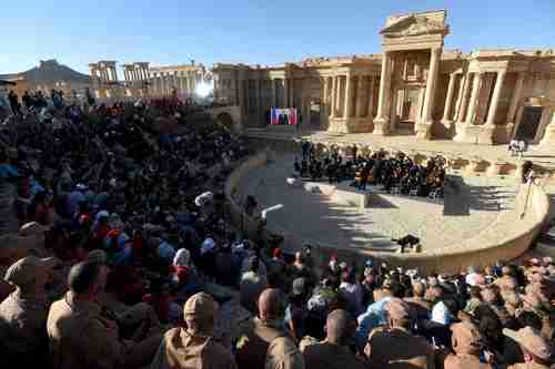 Russia holds a concert on 5-May to celebrate the recapture of Palmyra from ISIS.  Note that Vladimir Putin is on the wide-screen tv on the left side of the stage (AFP)