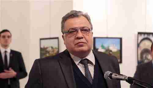 Andrey Karlov giving his speech in an Ankara art museum, just before being shot.  In the left rear is the assassin, Mevlt Mert Altintas. (Hurriyet)