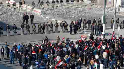 Security forces stand guard as supporters of Iraqi cleric Muqtada al-Sadr protest on Saturday.  The protests turned violent later.  (AFP)