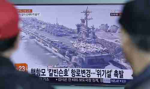 People in Seoul, South Korea, watch a TV news program showing a file image of the USS Carl Vinson aircraft carrier on Wednesday.  The caption reads 'The USS Carl Vinson aircraft carrier changes route.' (AP)