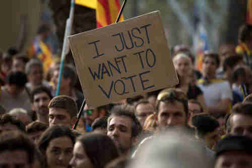 In Barcelona on Thursday, a protesters holds up a banner reading 'I just want to vote' (Getty)