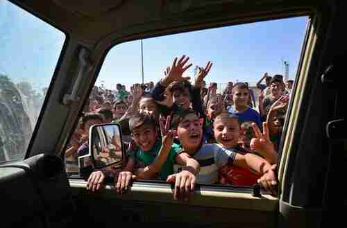 Children greet Iraqi soldiers as they enter the southern outskirts of Kirkuk on Monday (Reuters)