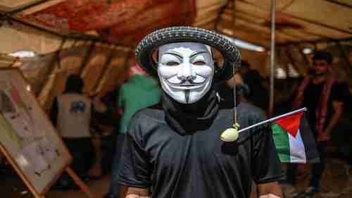 A Gaza protester wears a tire on his head with an onion (to protect himself from tear gas) dangling from it (al-Jazeera)